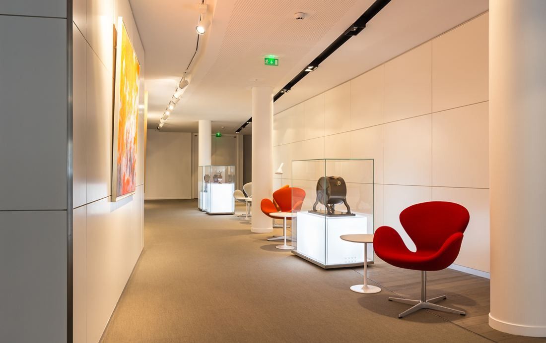 Crédit Agricole: A gallery corridor with artworks, display cases and red armchairs