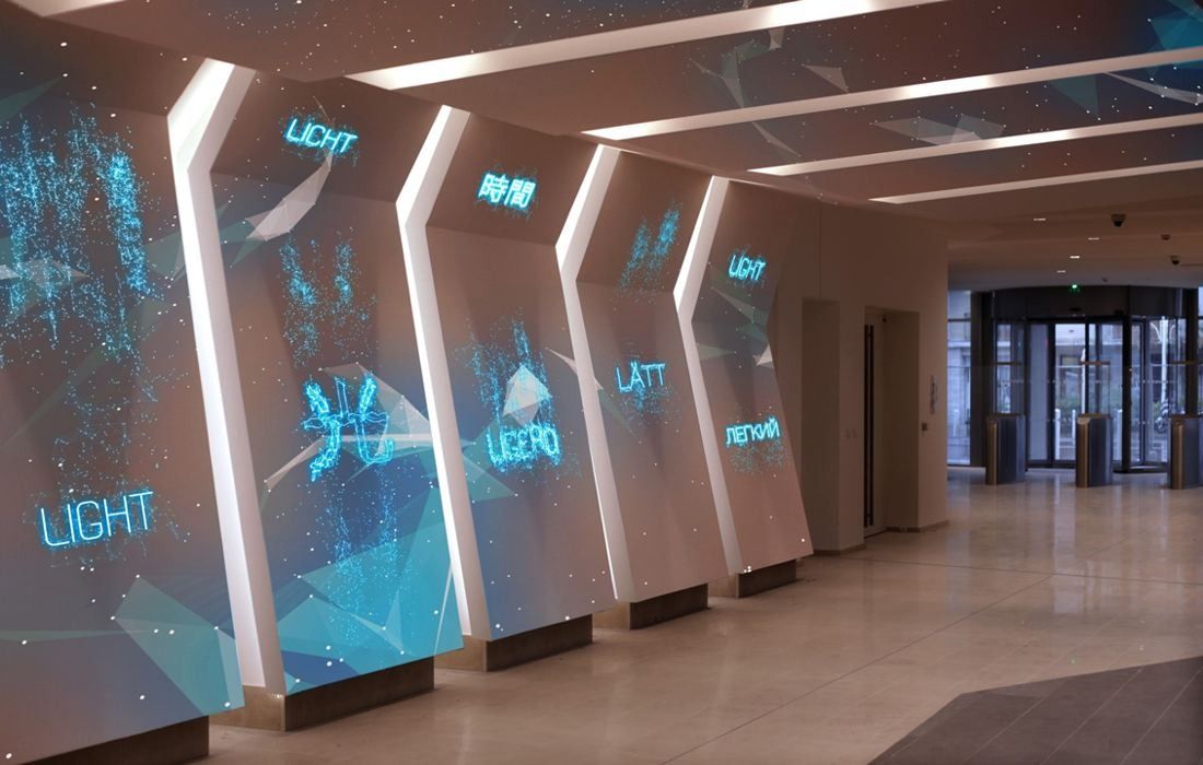 Crédit Agricole: A hall whose angled white panels carry blue light projections of words