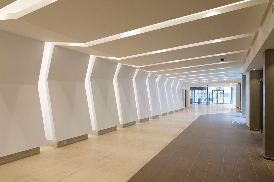 Crédit Agricole: A long white corridor lined with angled white arches and ceiling light strips