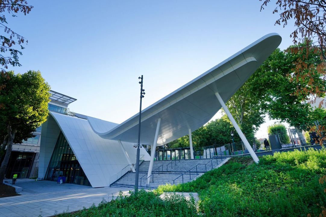 Crédit Agricole: A white curved canopy sweeping over a glazed pavilion among trees