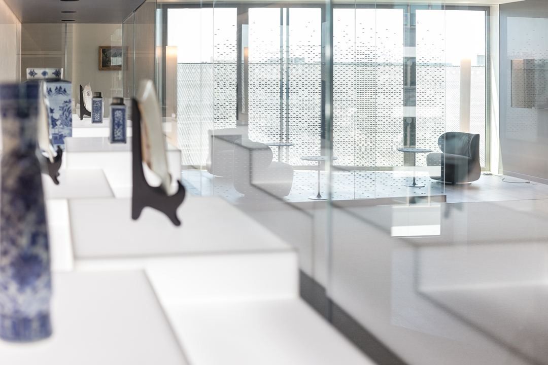 Crédit Agricole: A white lounge with glass display cases and a perforated screen