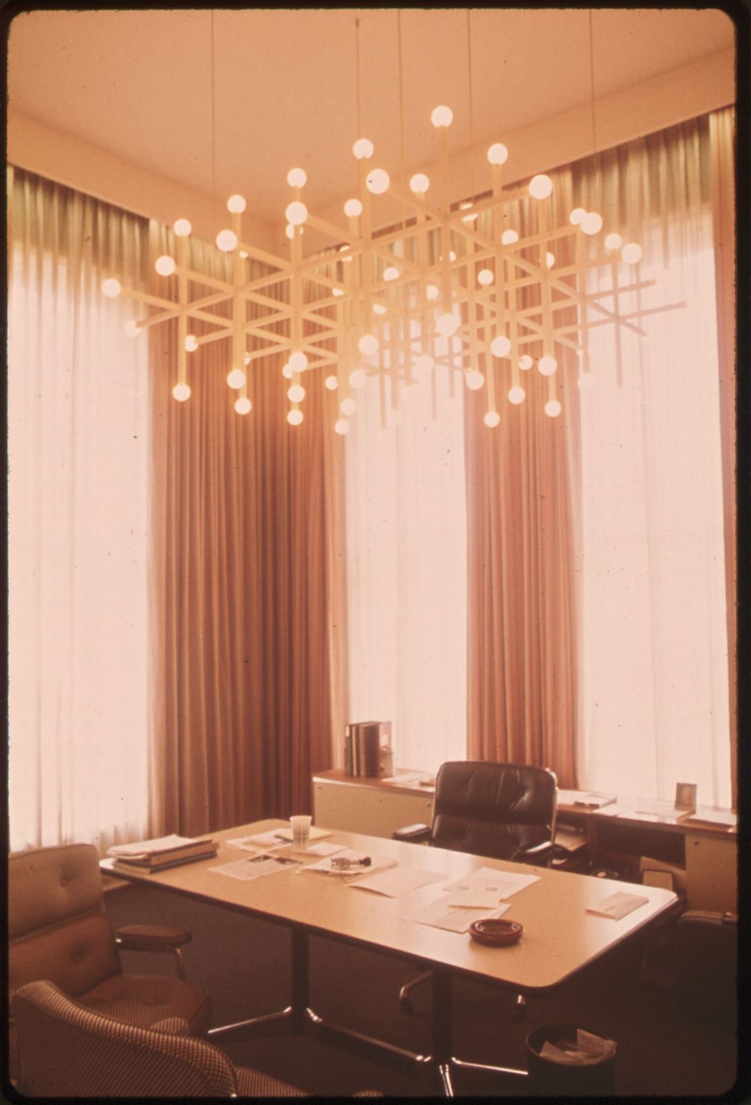 1970s office with long curtains and a chandelier of small lights