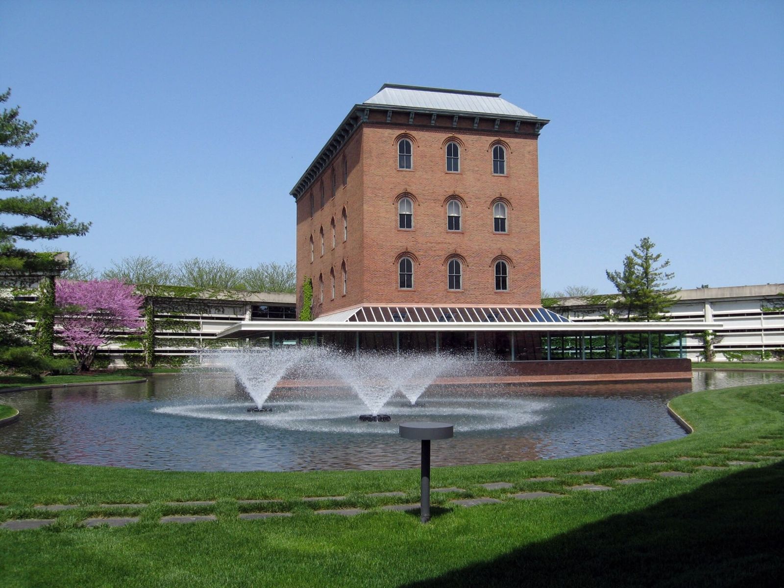Cummins: Brick mill building behind a fountain pond