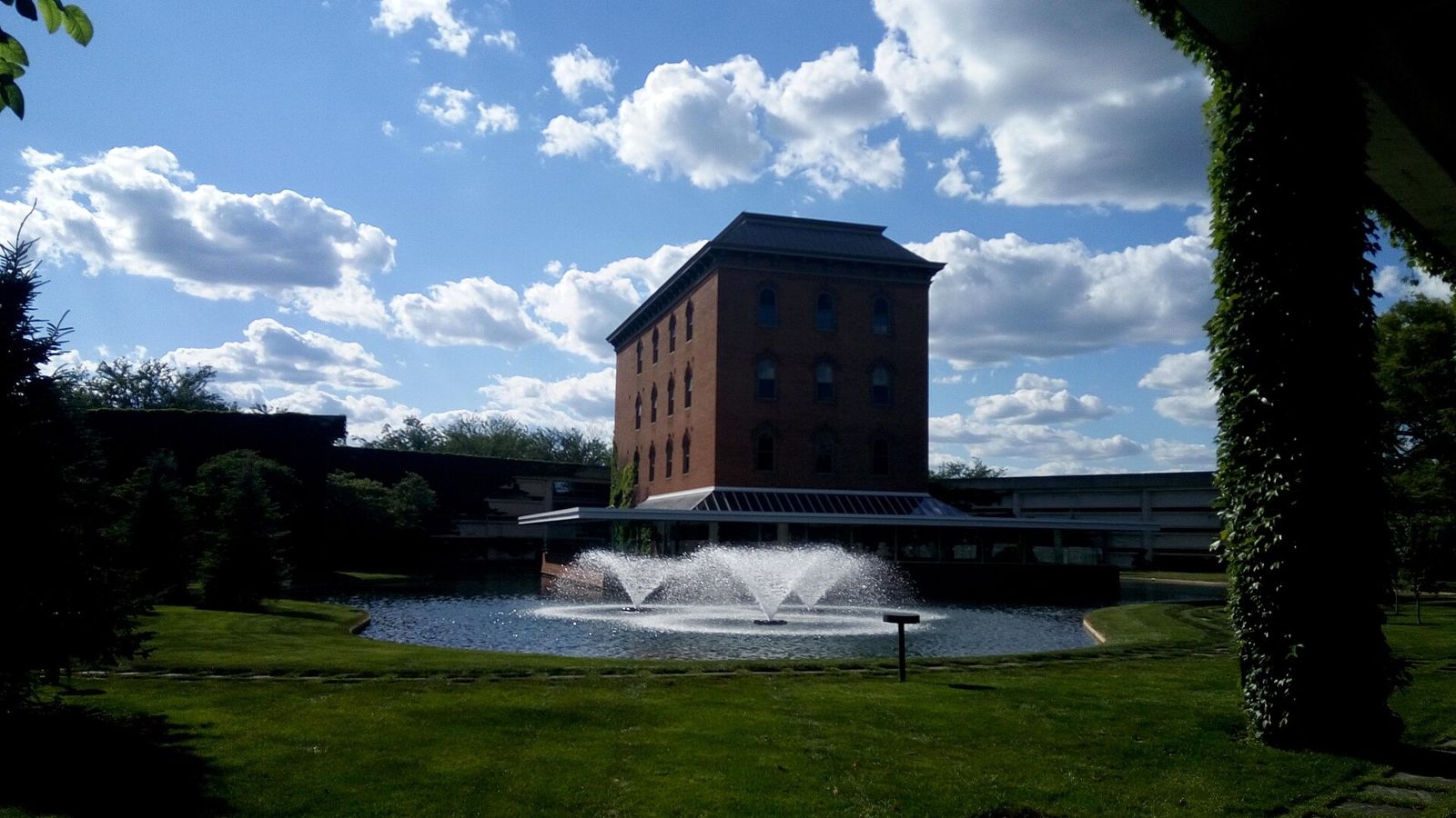 Cummins: Brick mill tower behind a fountain