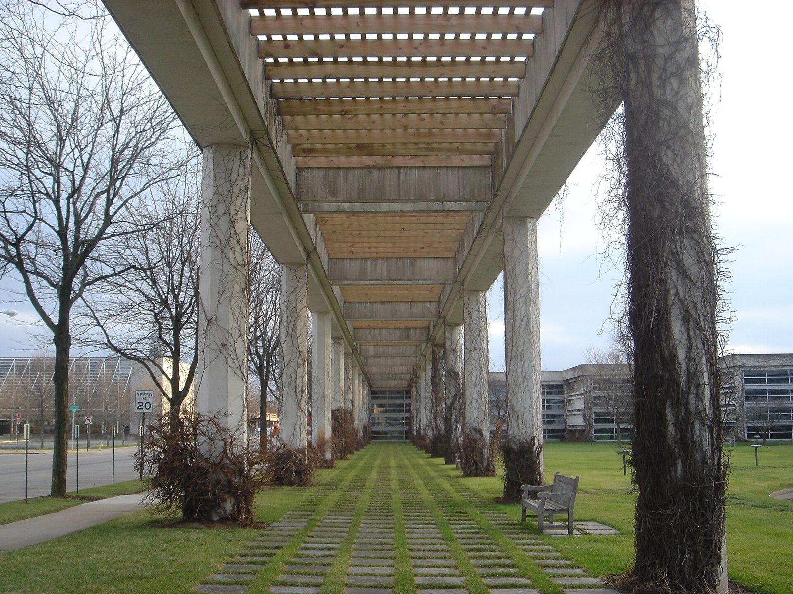 Cummins: Long concrete trellis walkway over grass pavers