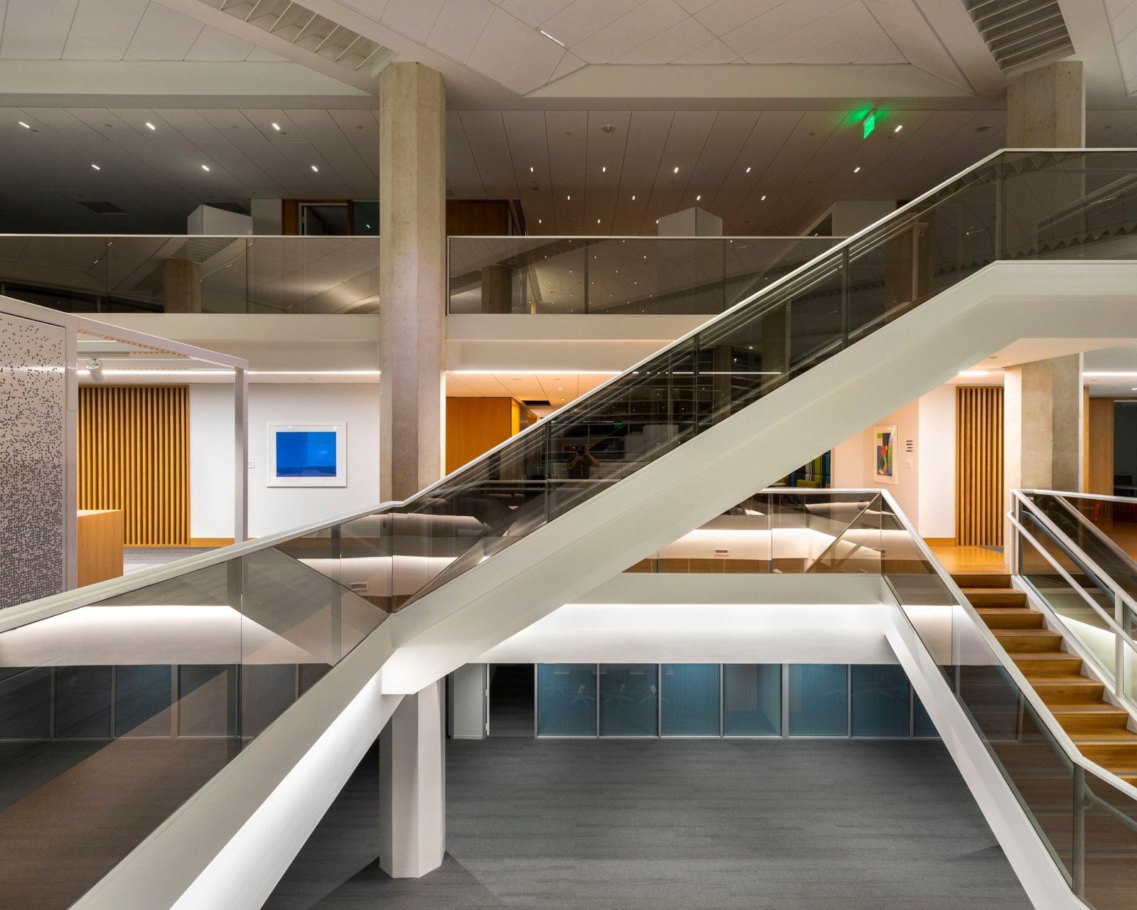 Cummins: Open stair with glass rails crossing a multi-level space