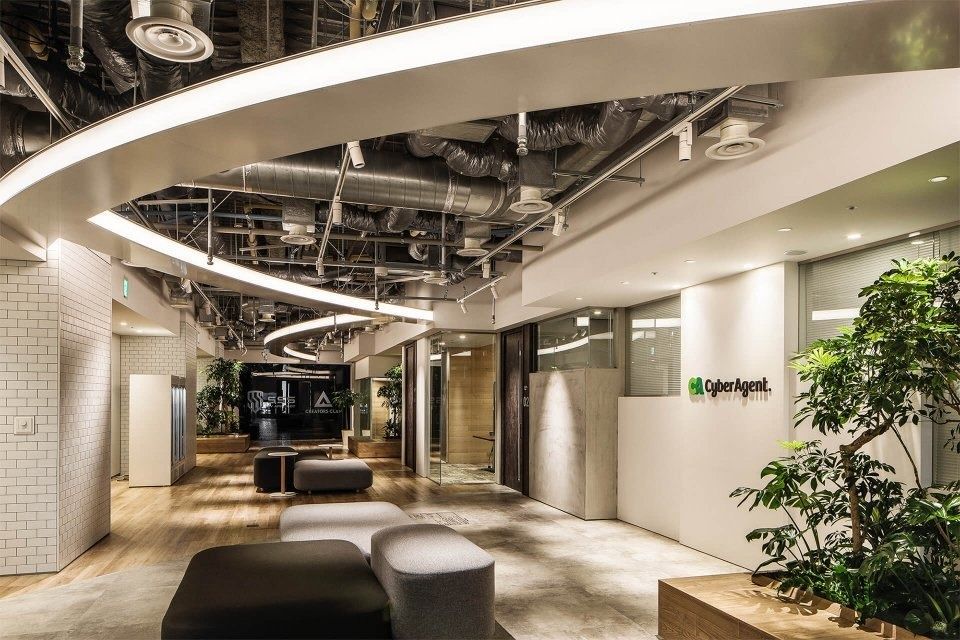 CyberAgent: Curved ceiling over a reception area with planters and benches