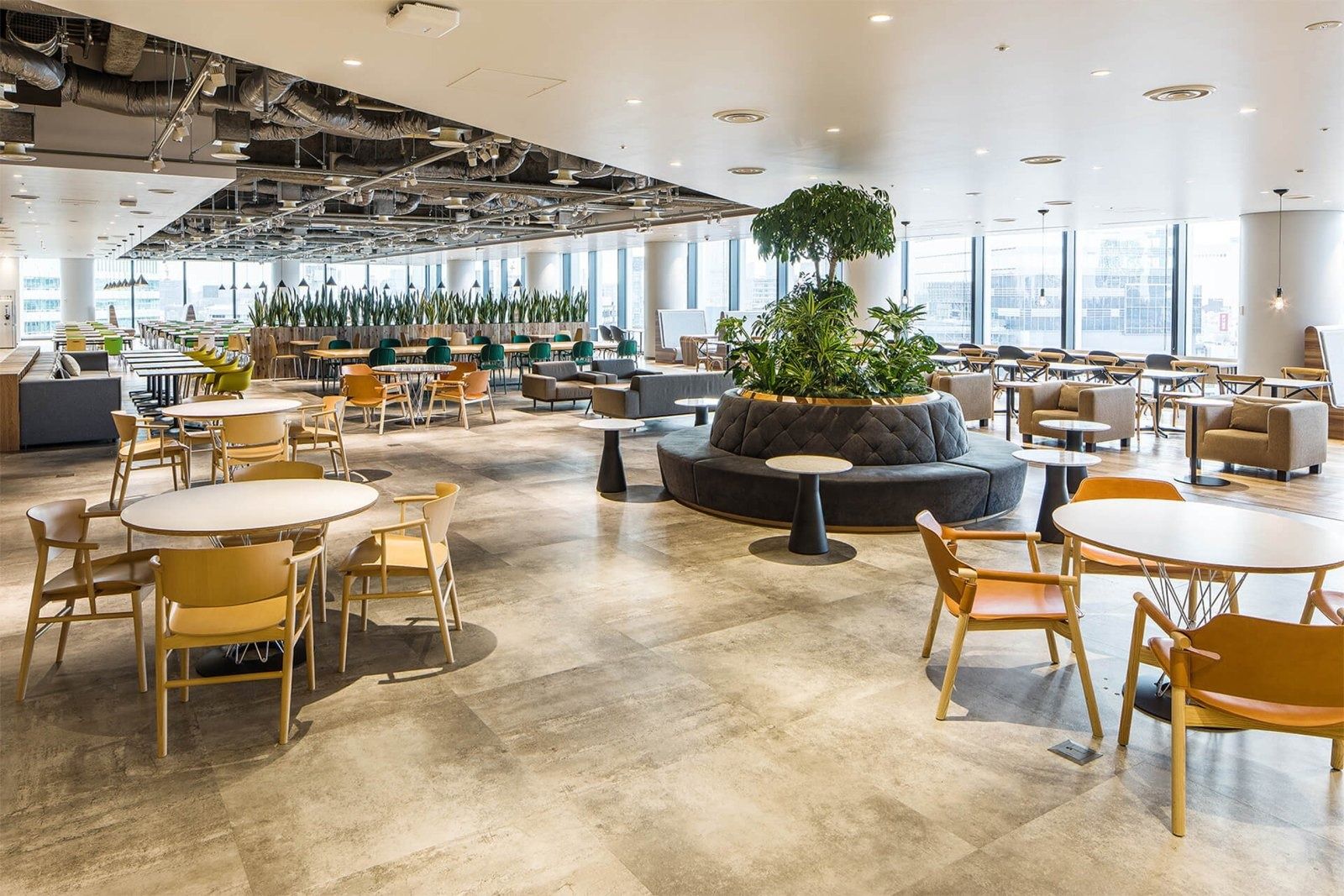 CyberAgent: Open lounge with round tables, wooden chairs and a central planter