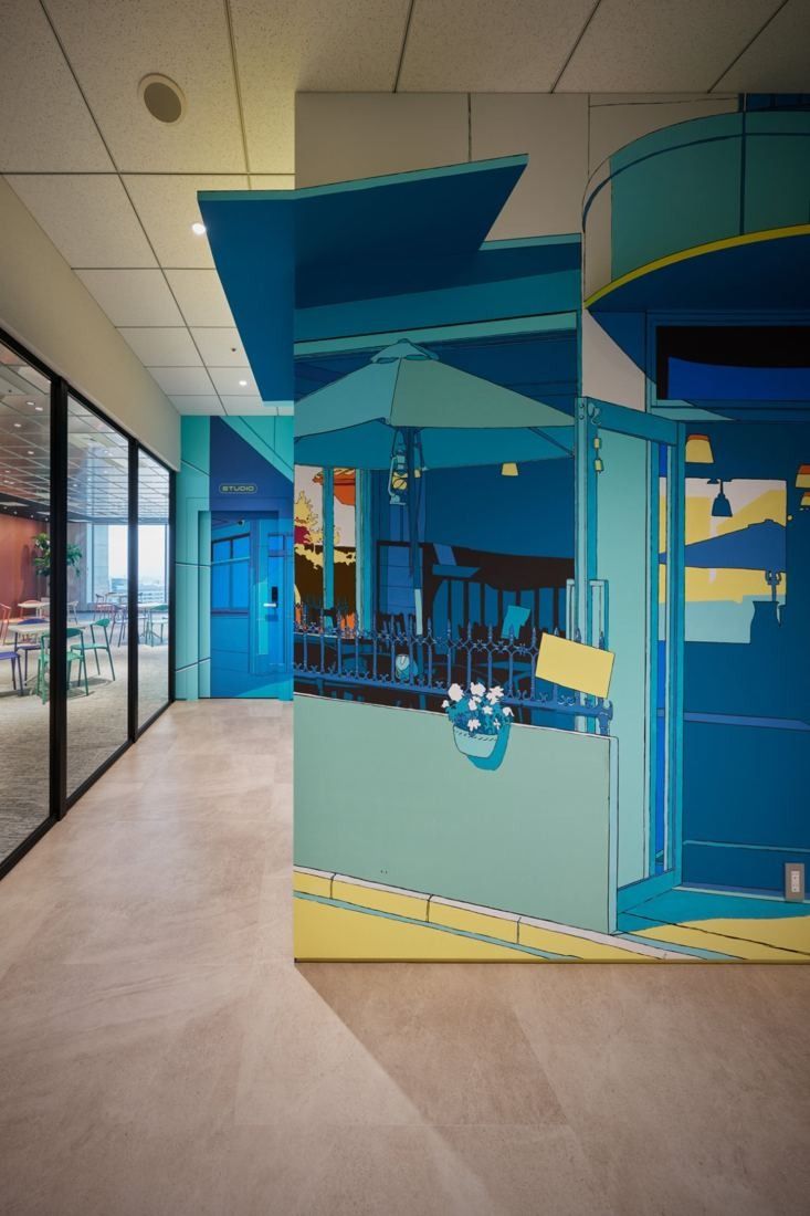 Cybozu: Corridor beside a blue illustrated wall with a house-shaped opening