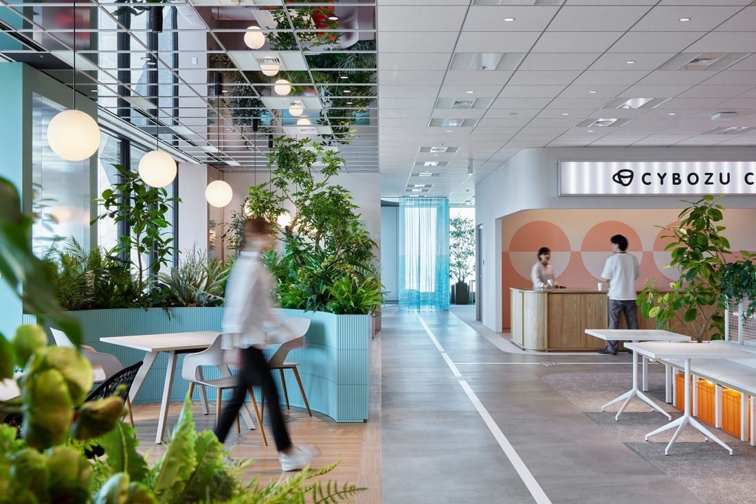 Cybozu: Path lined with planters and round pendant lamps leading to a café counter