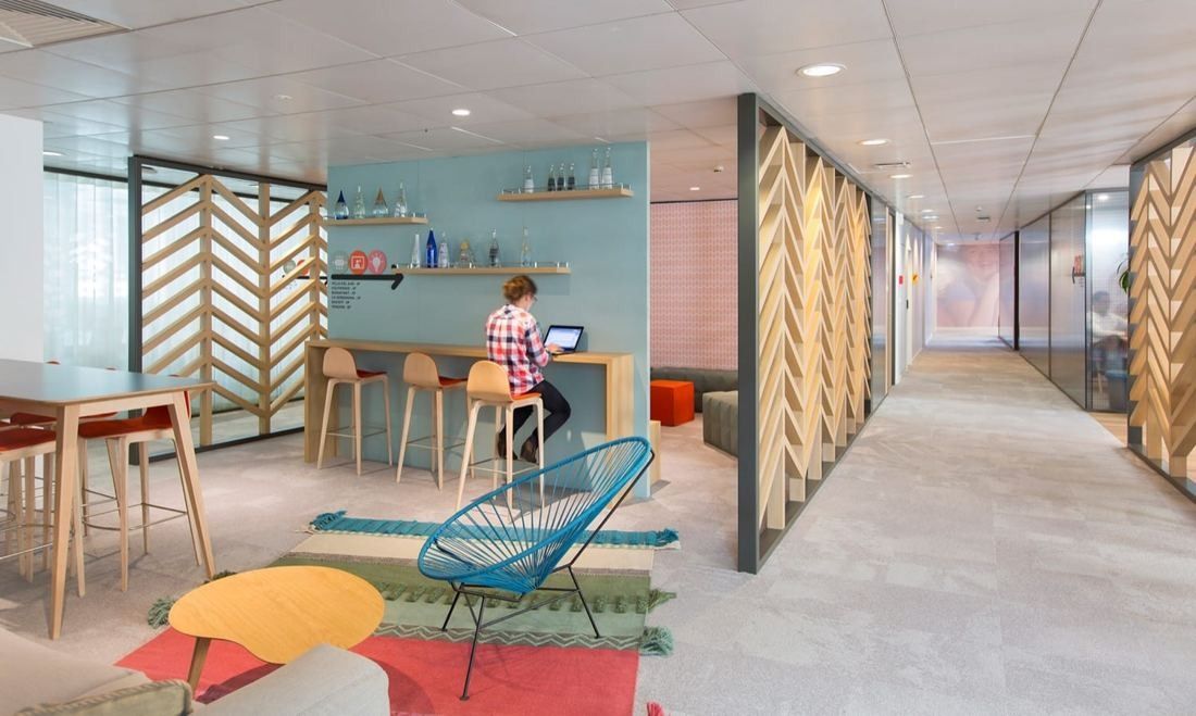 Danone: Corridor with herringbone timber screens, high tables and colourful rugs