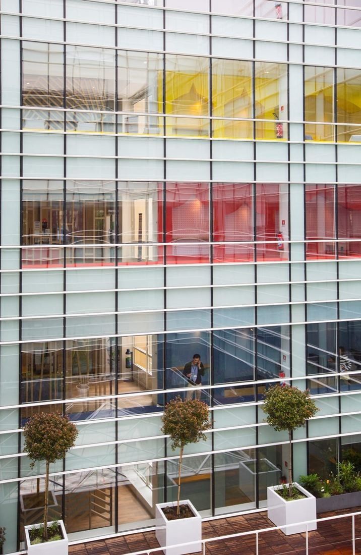 Danone: Glass-block facade around an inner courtyard with potted trees on balconies