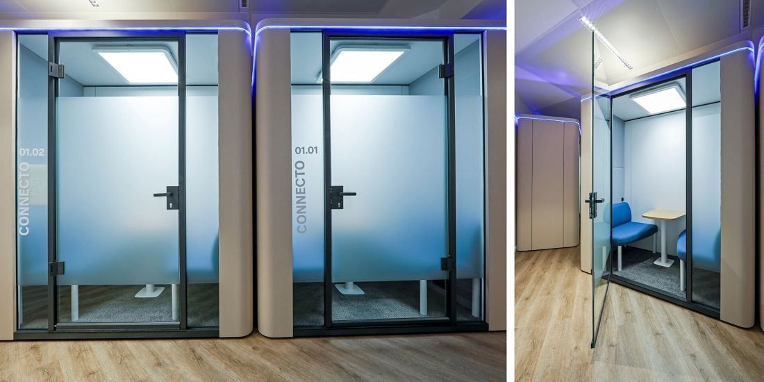 Danone: Row of glass room-in-room booths with frosted doors and violet light strips