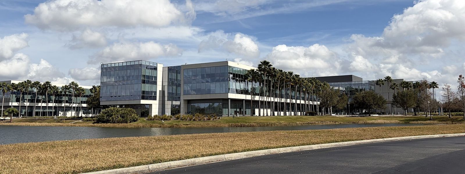 Darden Restaurants: Glass office wings beyond a lake shore and a curving road