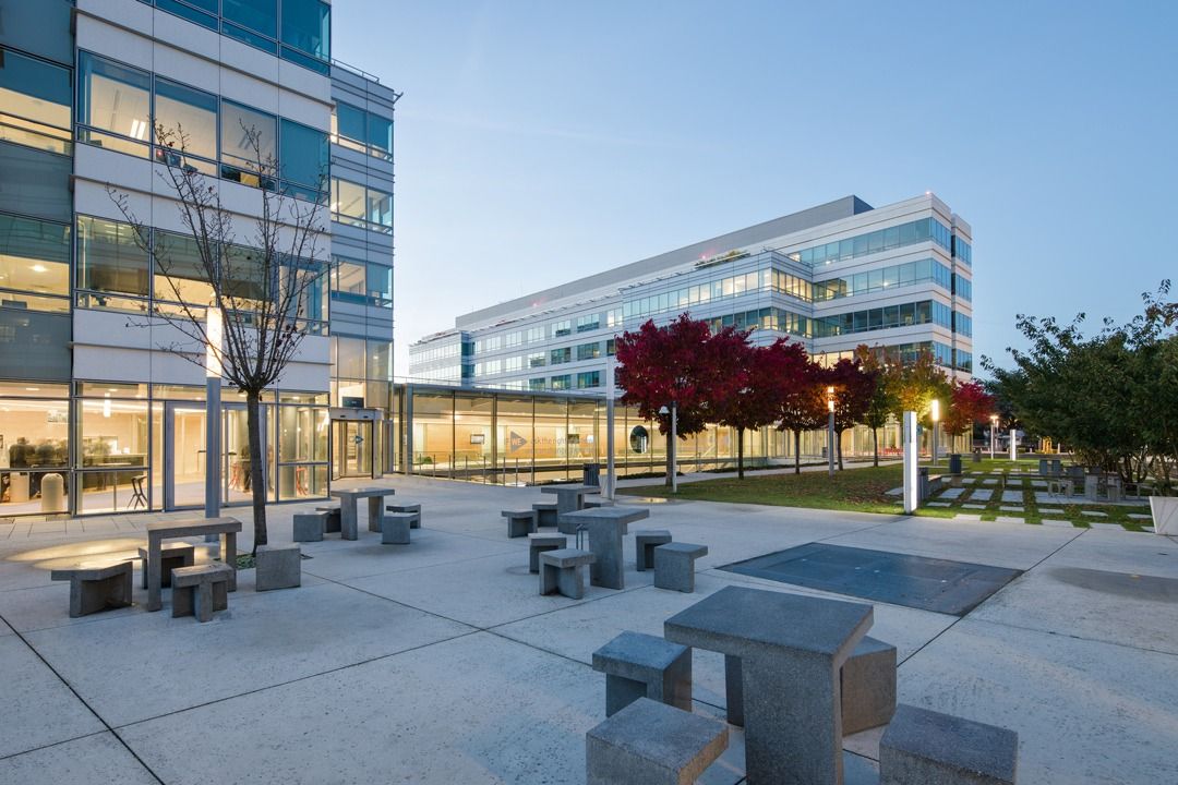 Dassault Systèmes: Paved courtyard with stone tables beside the buildings
