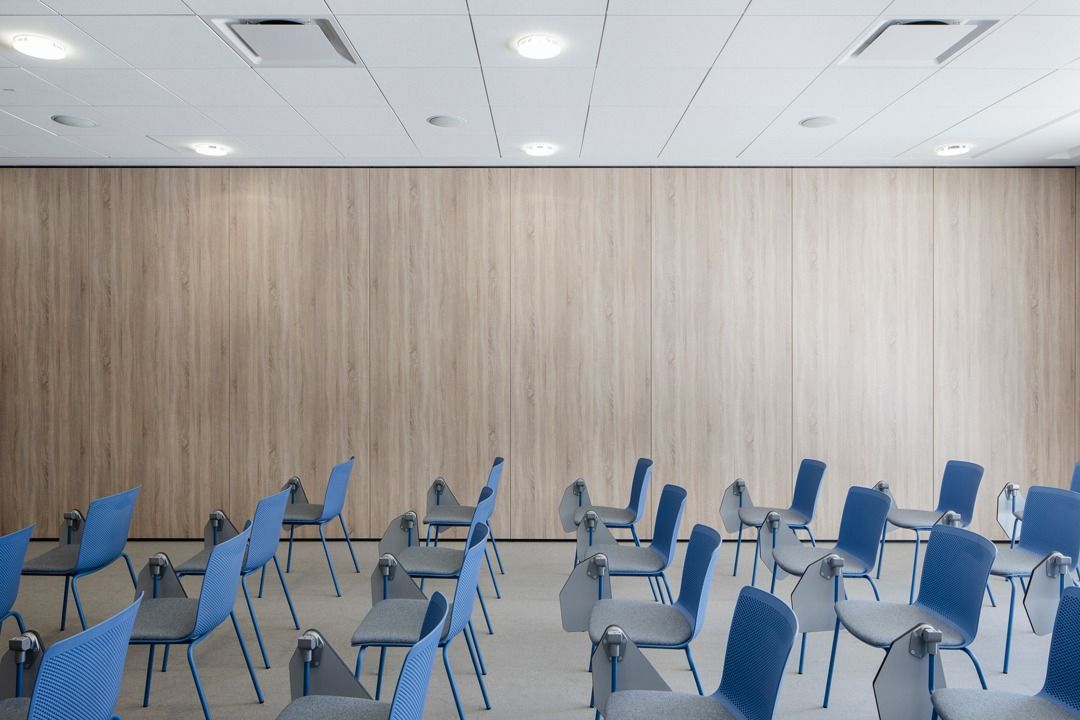 Dassault Systèmes: Room with blue chairs and a timber wall