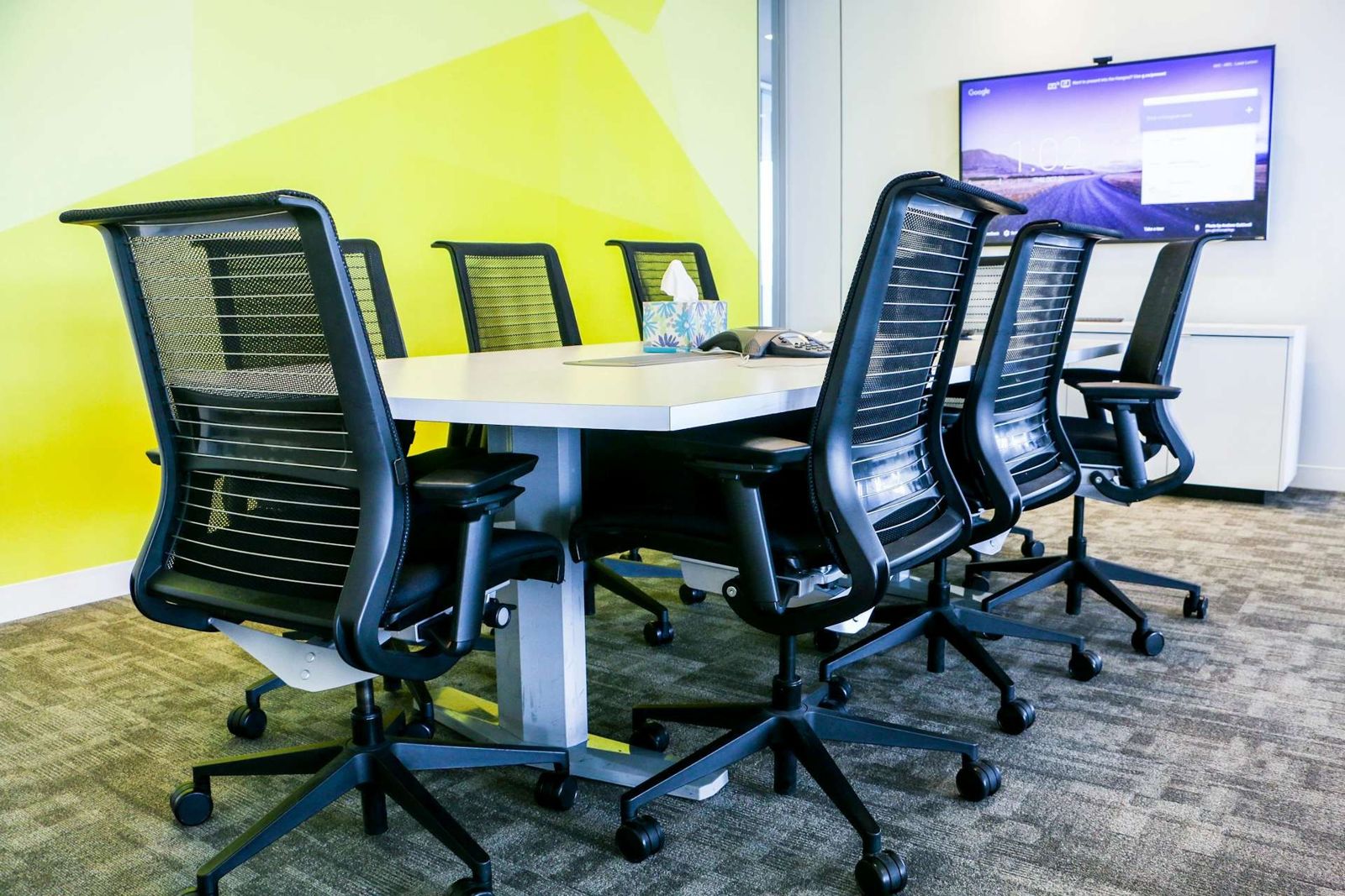 Datadog: Meeting room with black office chairs and a wall screen