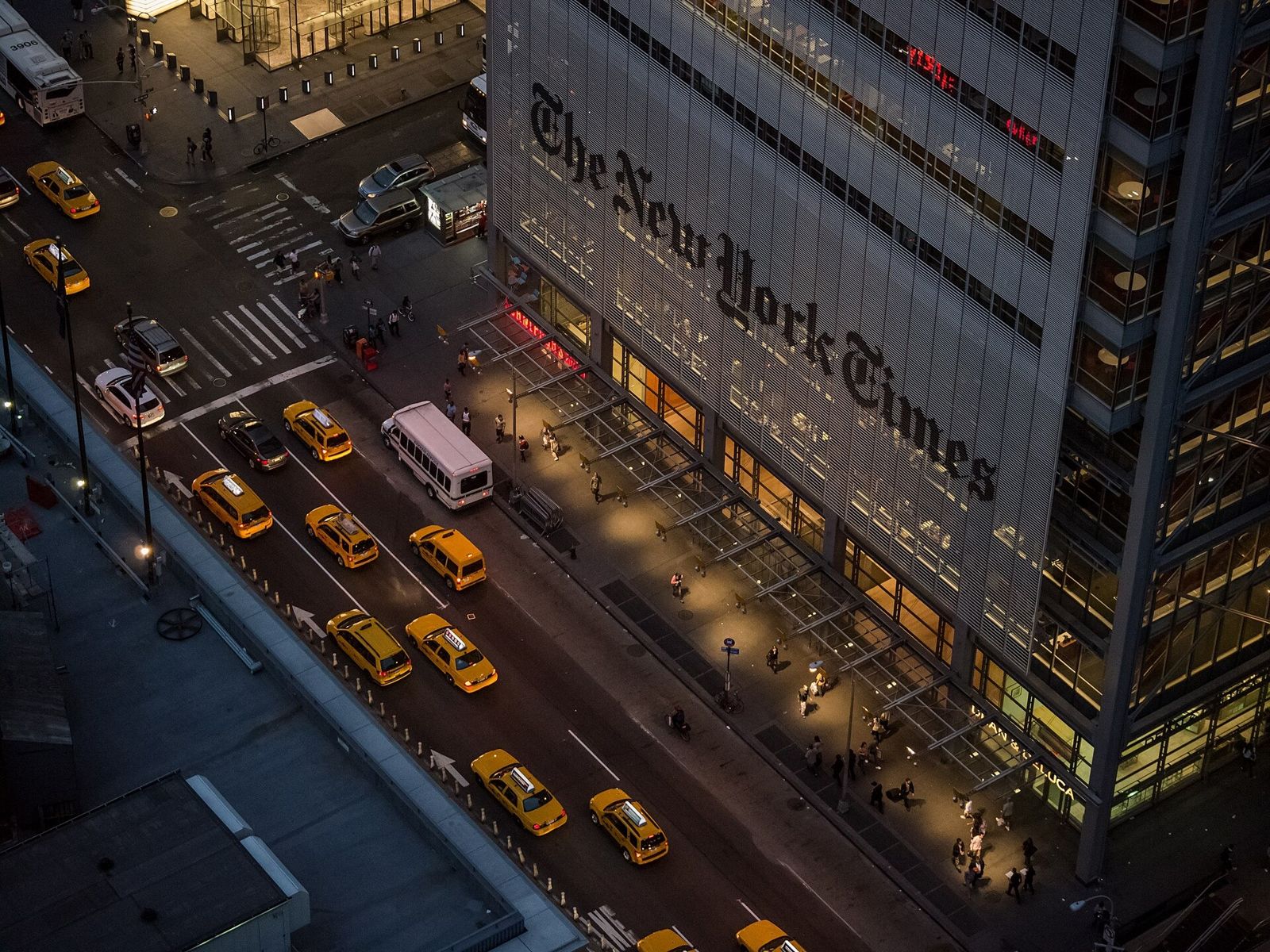 Datadog: The tower lit at night above Eighth Avenue and yellow taxis