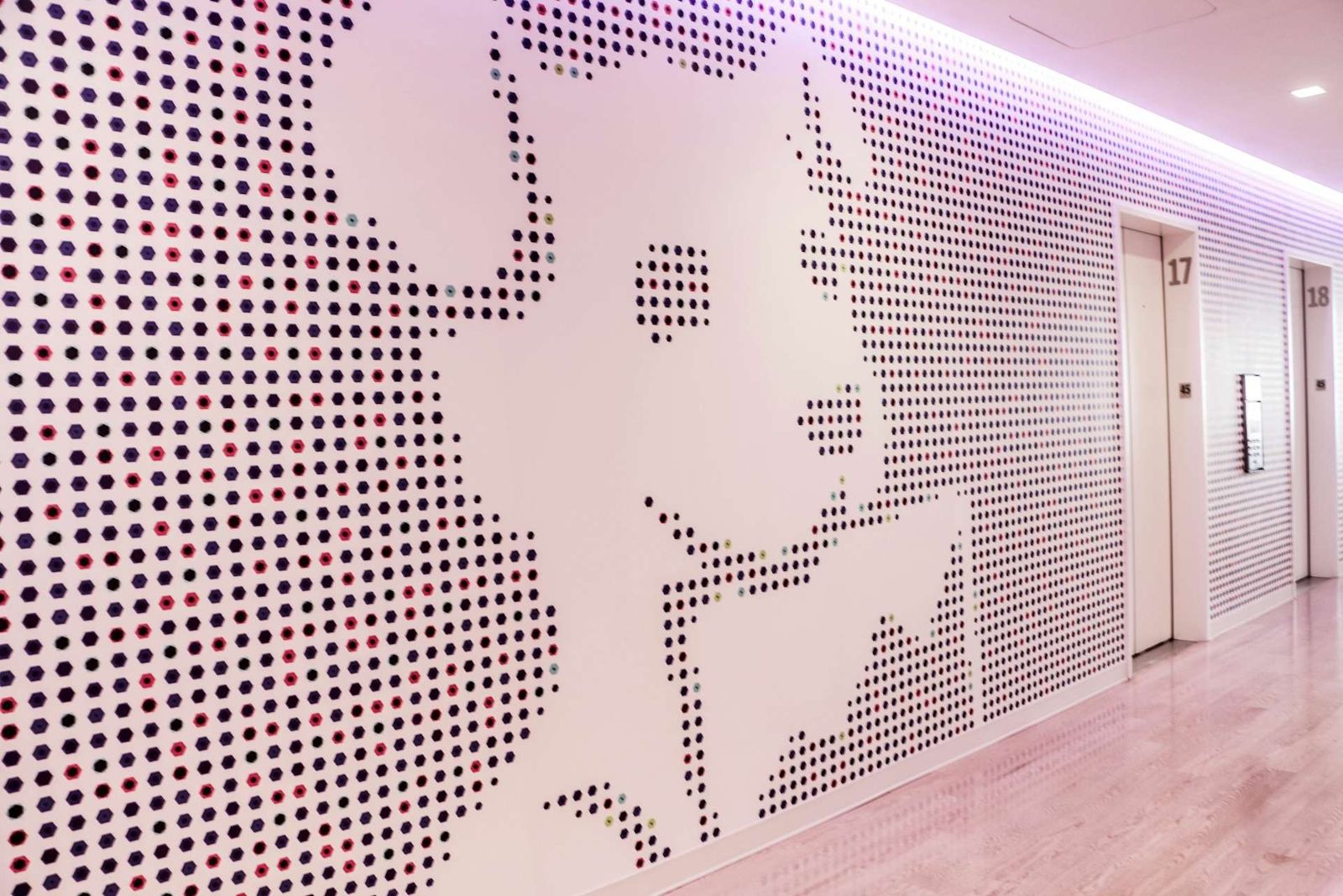Datadog: White wall with a large dotted pattern along a corridor