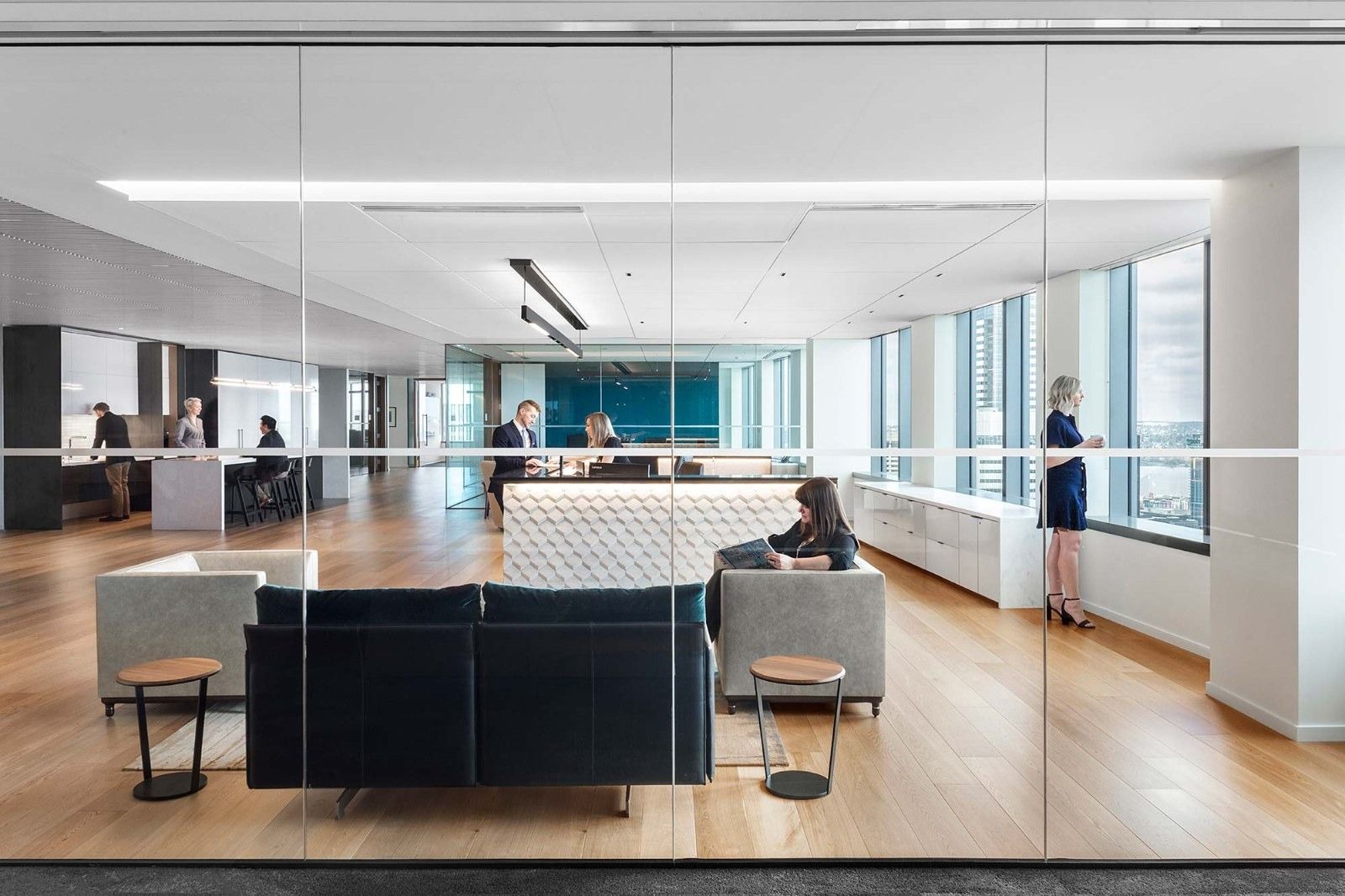 Davis Wright Tremaine: A lounge with dark sofas behind glass walls
