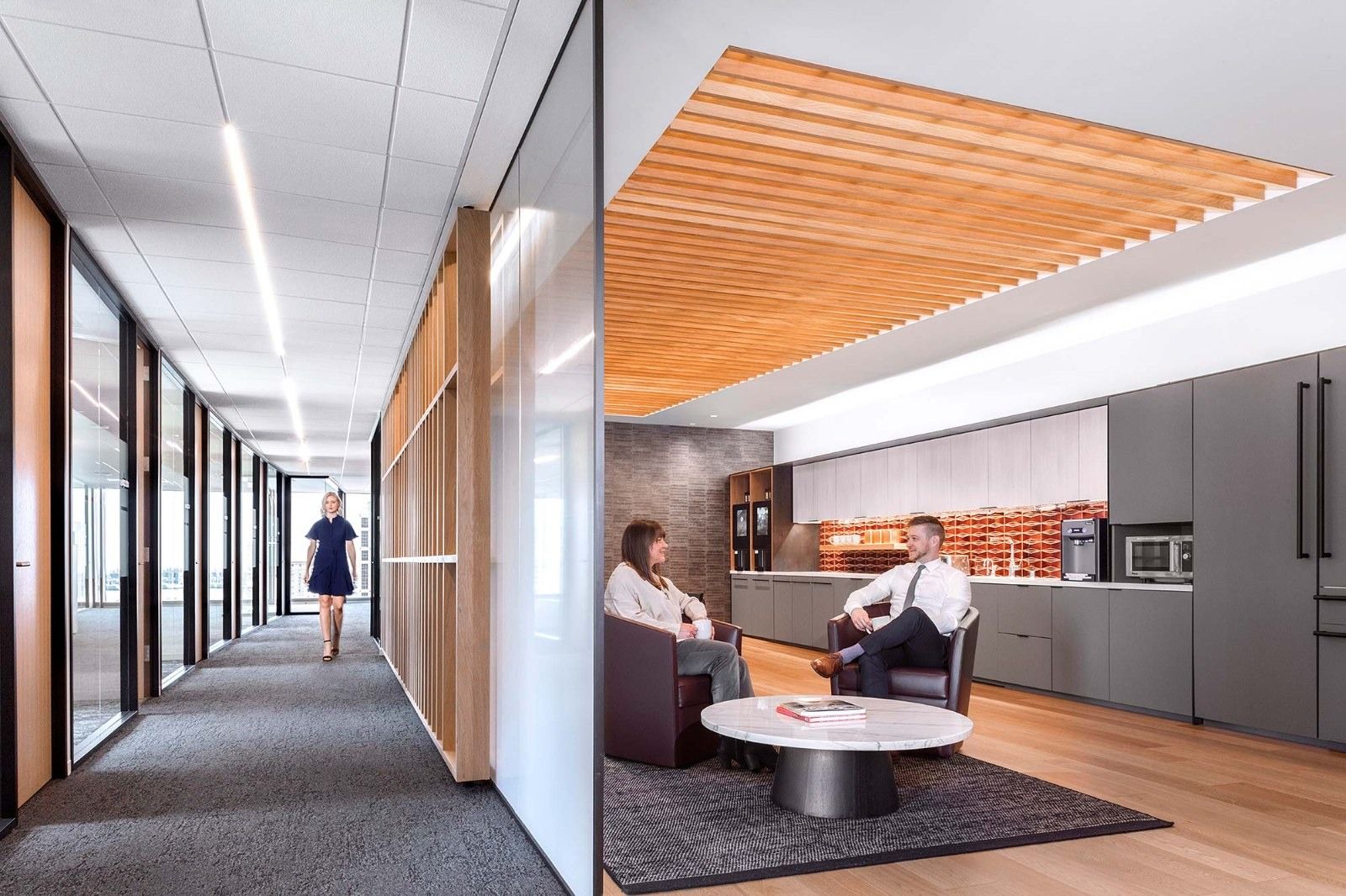 Davis Wright Tremaine: A small lounge with an orange wood ceiling and round table