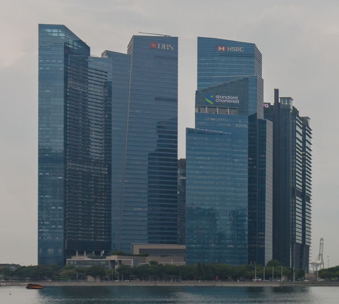 DBS Bank: Close view of the dark blue glass towers with DBS logos on the crowns