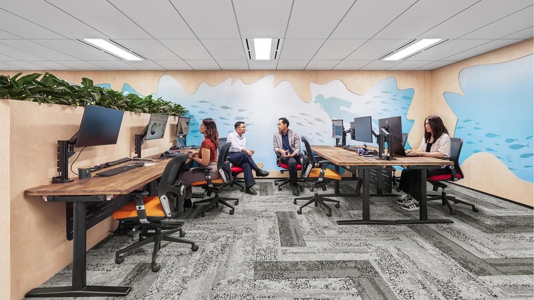 DBS Bank: Desks with monitors in a room painted with an underwater scene of fish and a diver