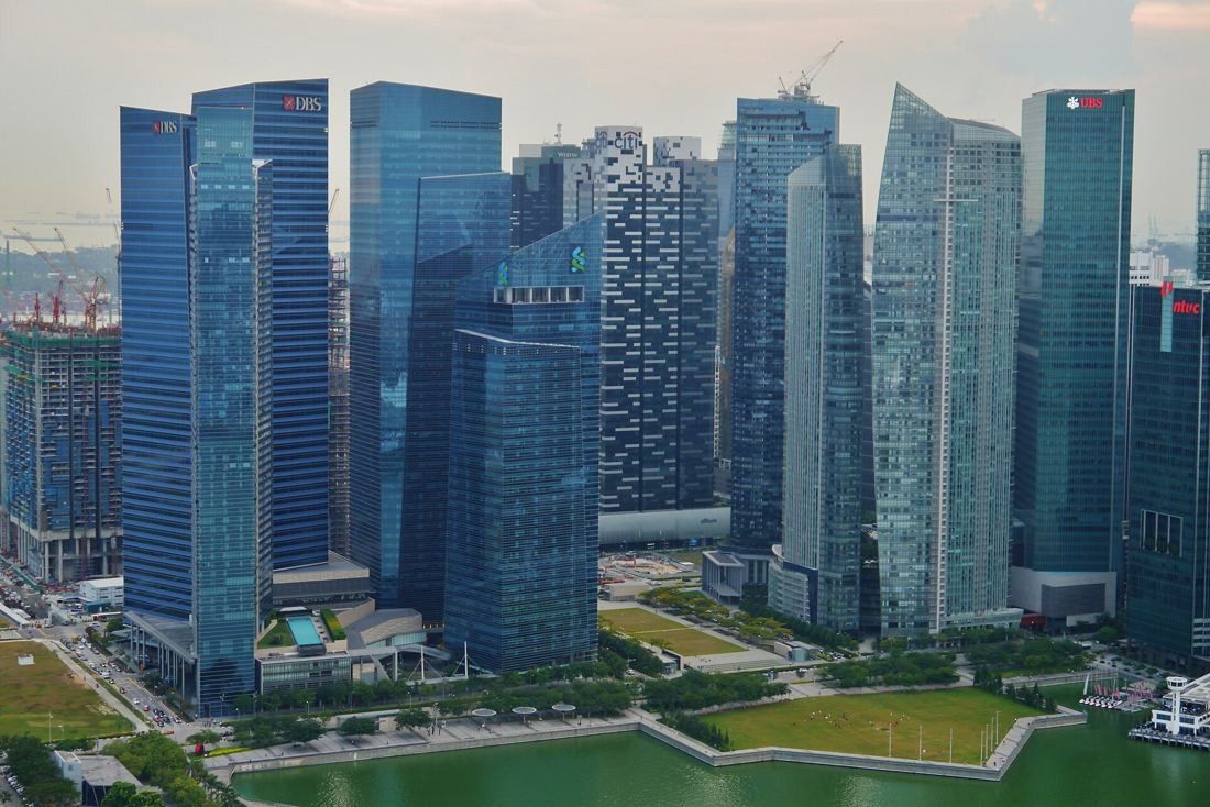 DBS Bank: Elevated view of the towers above a green park and lawns by the water