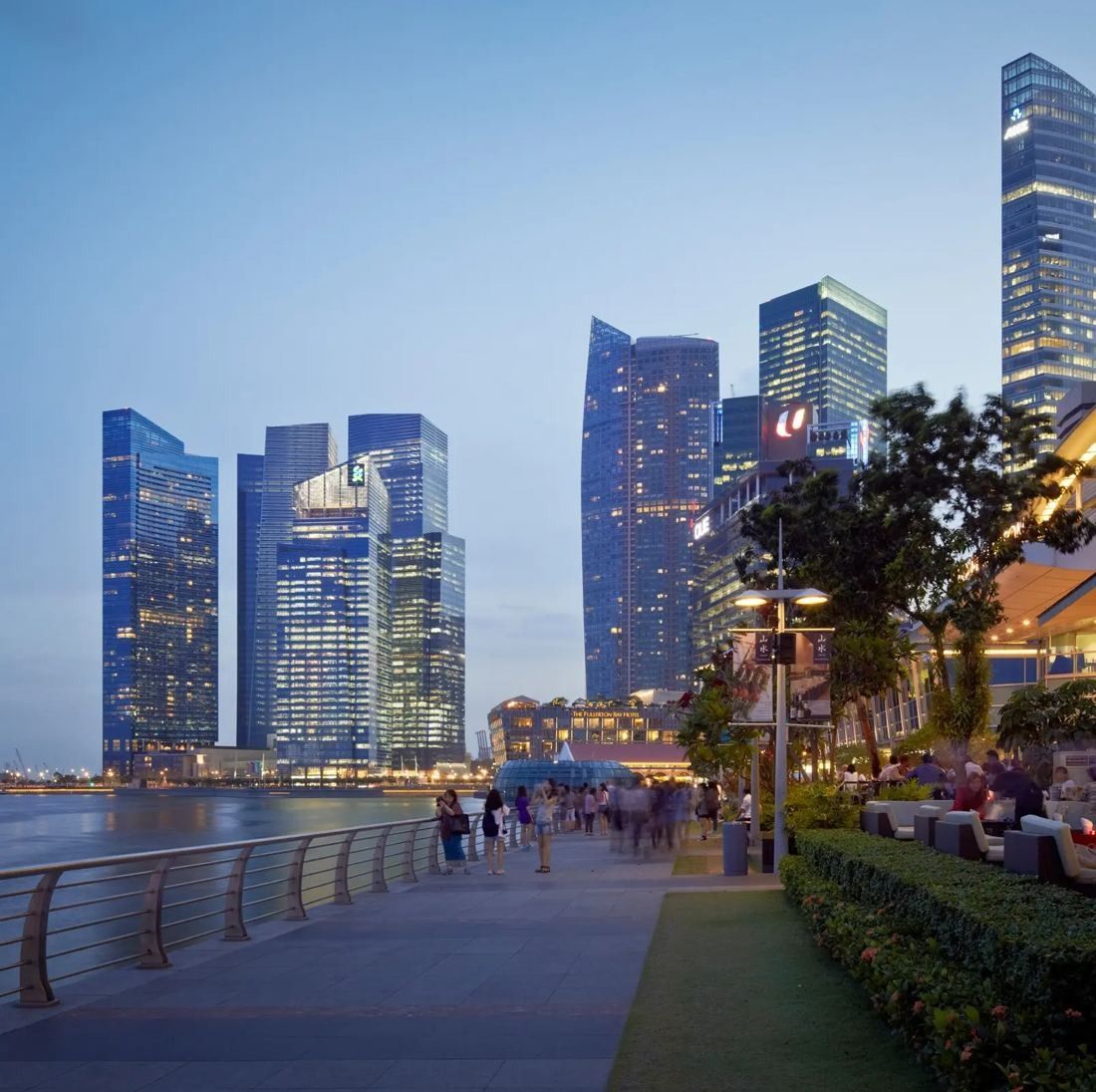 DBS Bank: Marina Bay Financial Centre towers at dusk behind a waterfront promenade