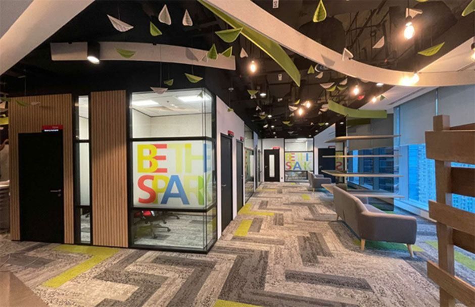 DBS Bank: Office corridor with a curving leaf-patterned ceiling, glass-walled rooms and a lounge area