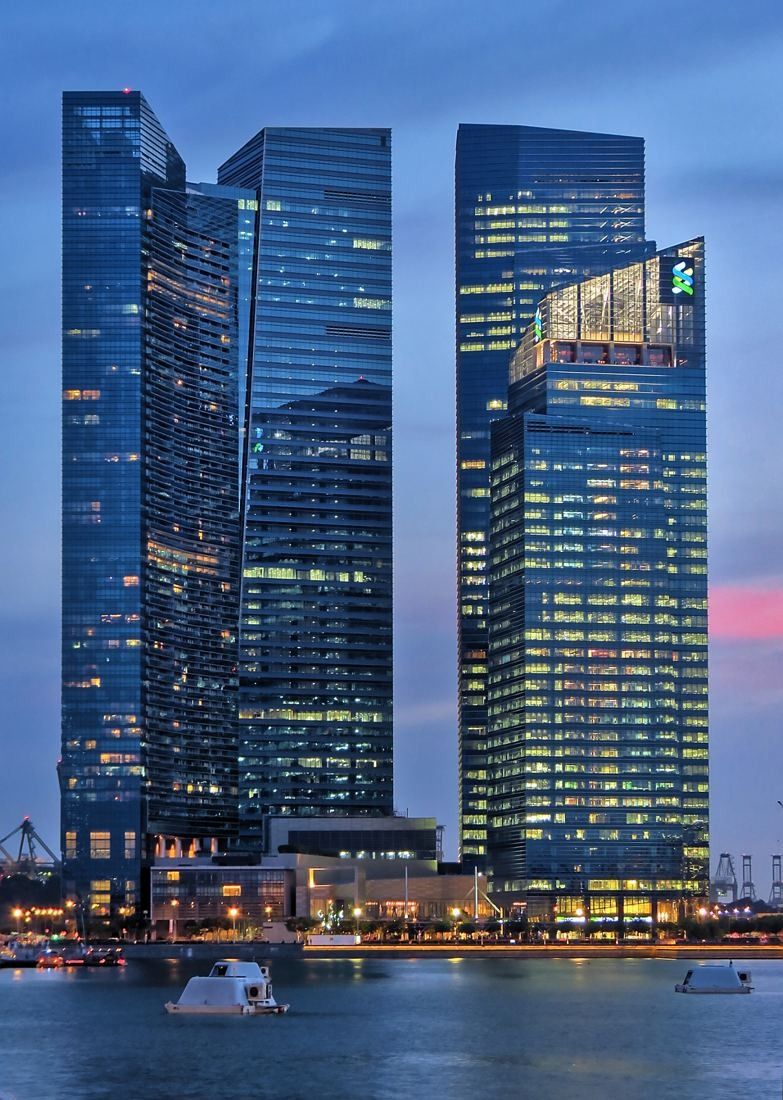 DBS Bank: Two glass towers lit at blue hour above the water