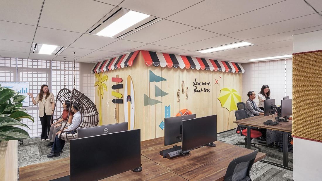 DBS Bank: Workspace with a striped market-stall awning, hanging rattan chairs and desks with monitors