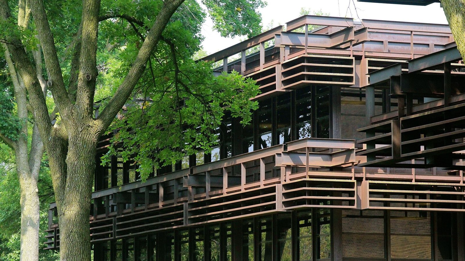 John Deere: Steel sunshades on a building among leafy trees