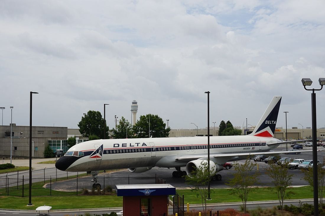 Delta Air Lines: Boeing 757 in vintage Delta livery displayed on a lawn, with an airport control tower on the horizon