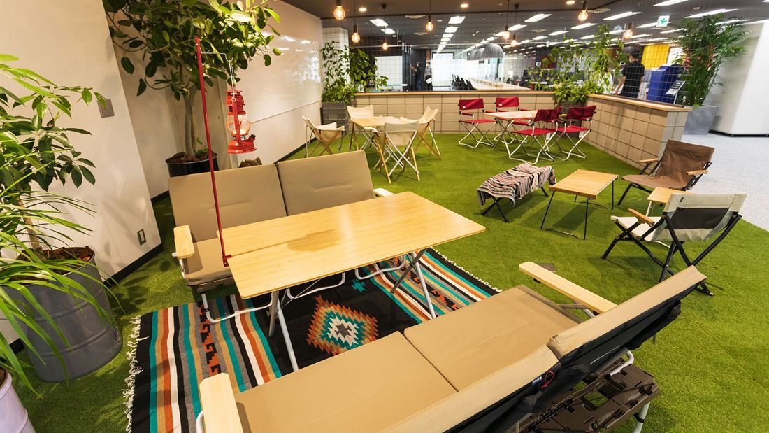 DeNA: Artificial lawn with folding camp chairs, tables and plants