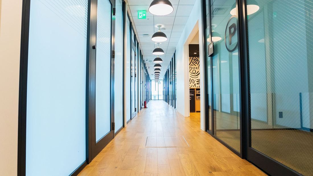 DeNA: Corridor with glass-walled rooms on both sides and pendant lights