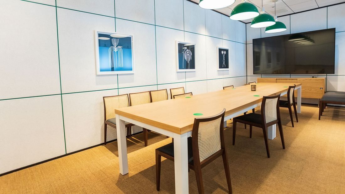 DeNA: Meeting room with a long wooden table, framed pictures and a wall screen