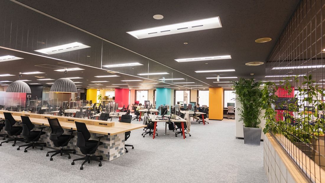 DeNA: Wide office floor with rows of desks and colourful walls