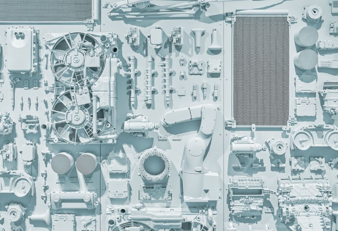 Denso: Wall relief made of many car parts, fans and radiators, all painted pale blue-grey
