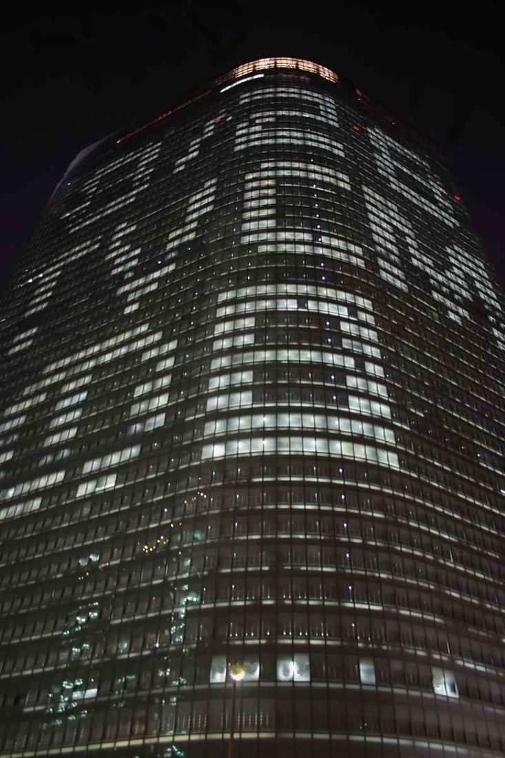 Dentsu: Lit windows on the tower facade forming large letters at night