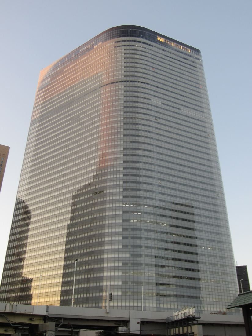 Dentsu: Rounded glass tower with a warm reflection at the top
