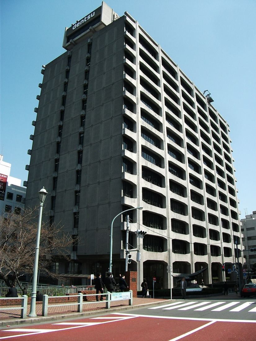 Tall concrete office building with deep horizontal bands of windows on a street corner