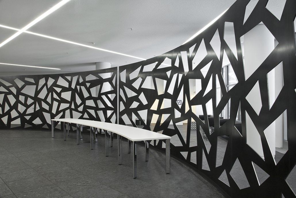 Deutsche Bank: Long curved black lattice wall beside a white table