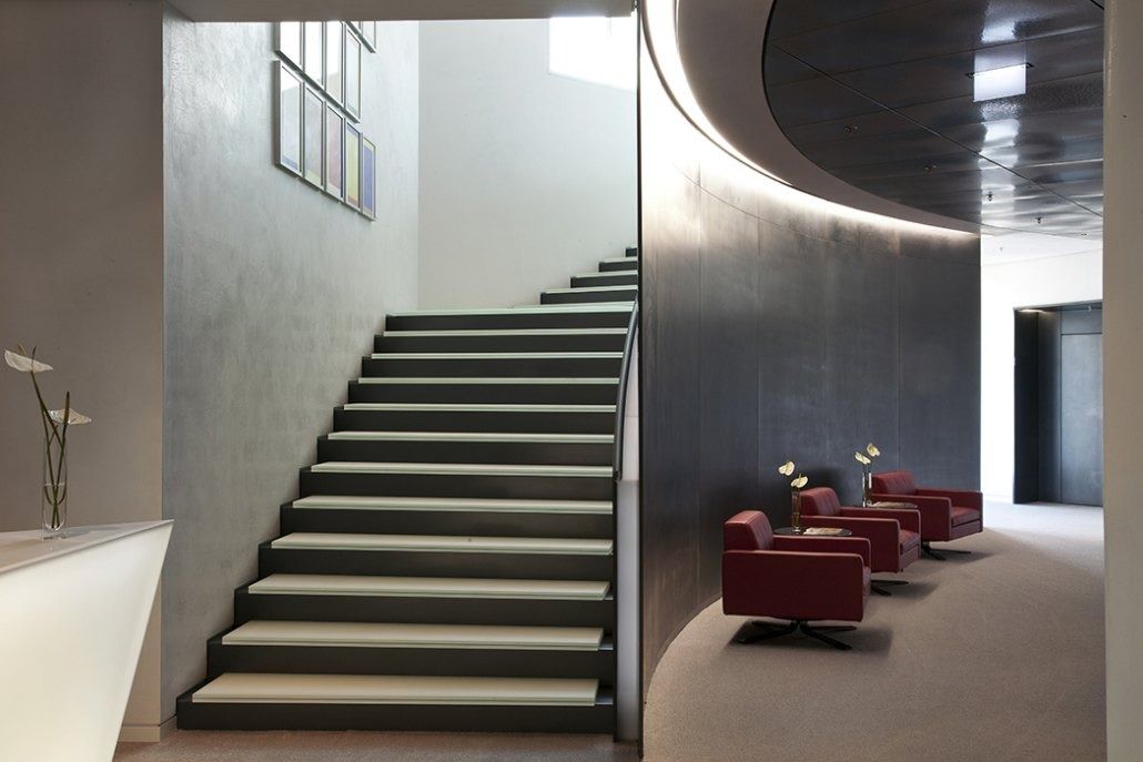 Deutsche Bank: Stone staircase next to a seating area with red armchairs