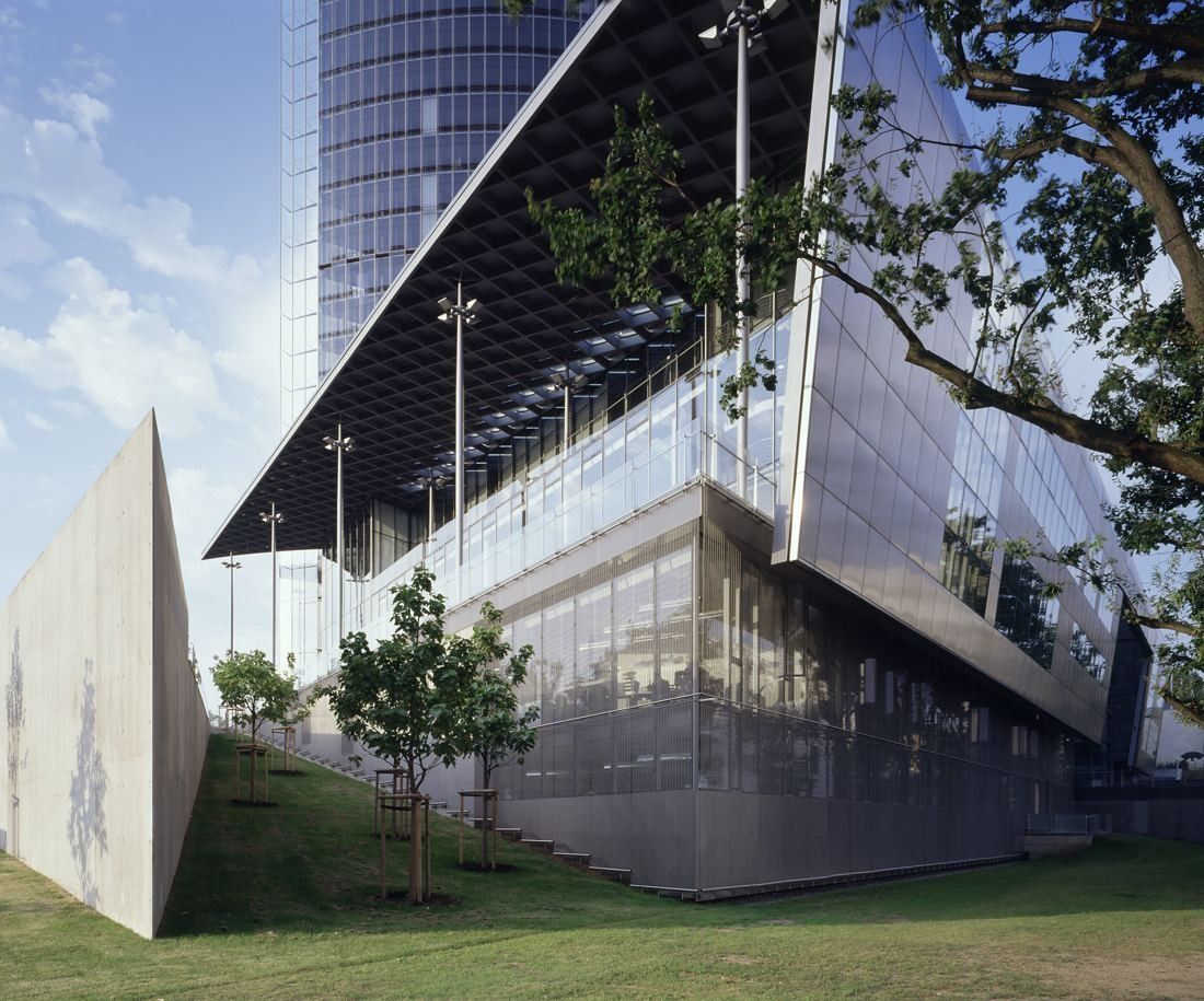 DHL Group: Angled glass base building with a projecting roof beside a lawn