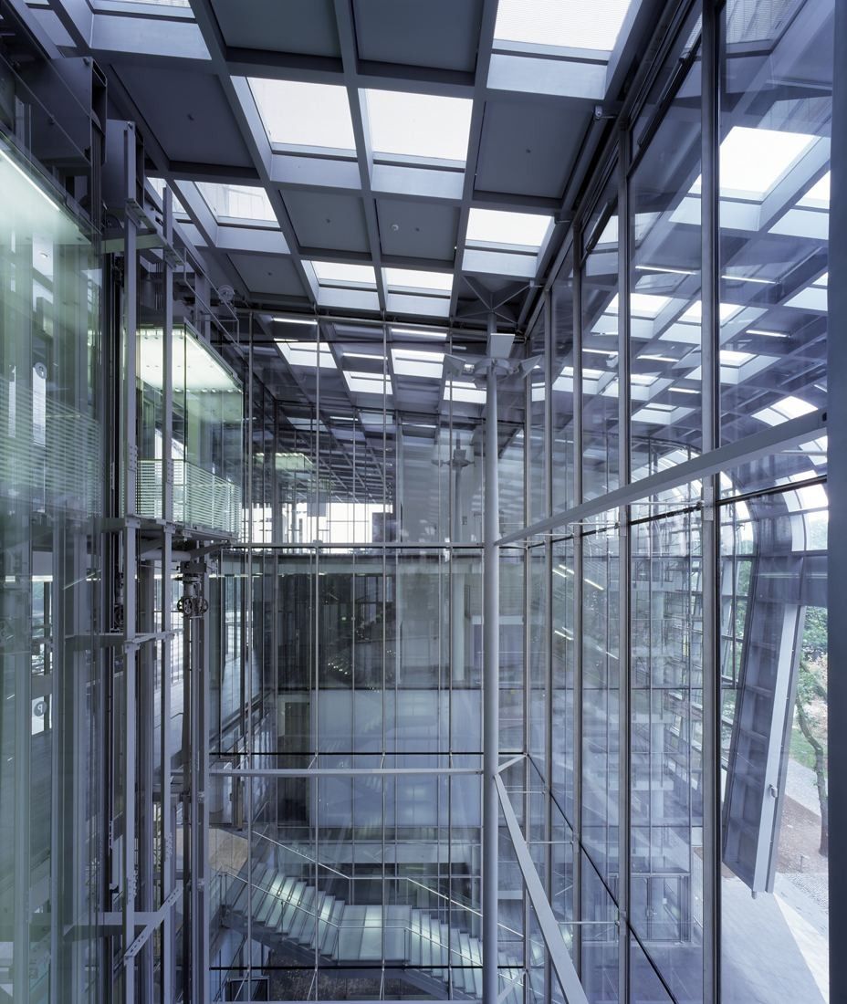 DHL Group: Tall glass atrium with steel bracing and stairs between office floors