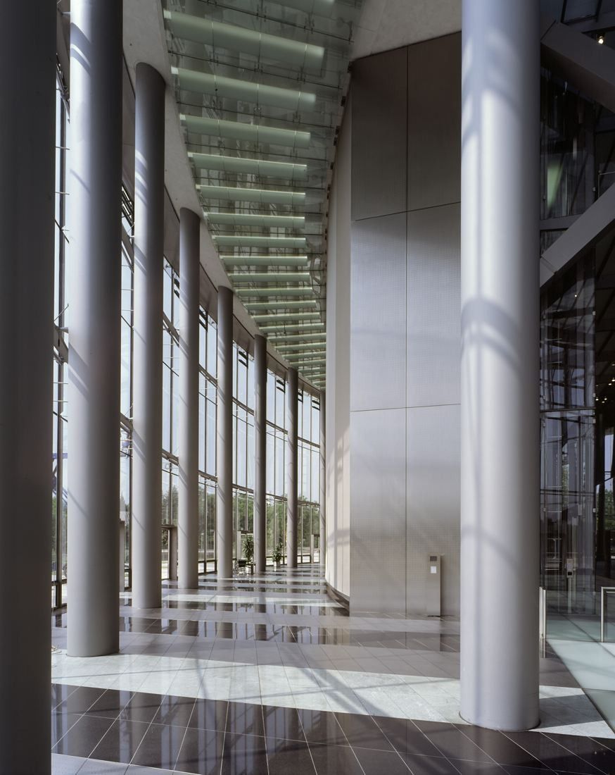 DHL Group: Tall glass hall with slim steel columns and a polished floor