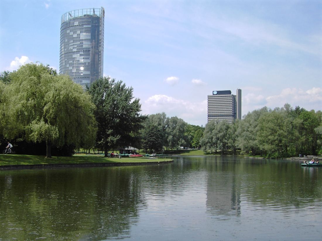 DHL Group: Tower above willows and a lake in the Rheinaue park