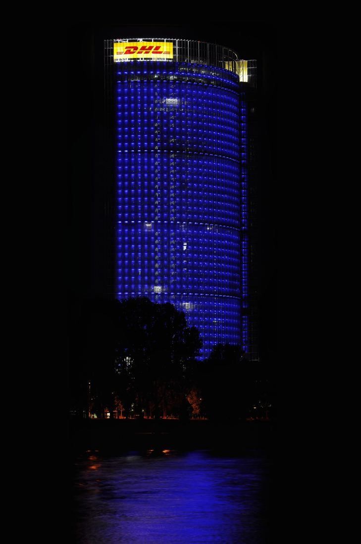 DHL Group: Tower glowing blue at night