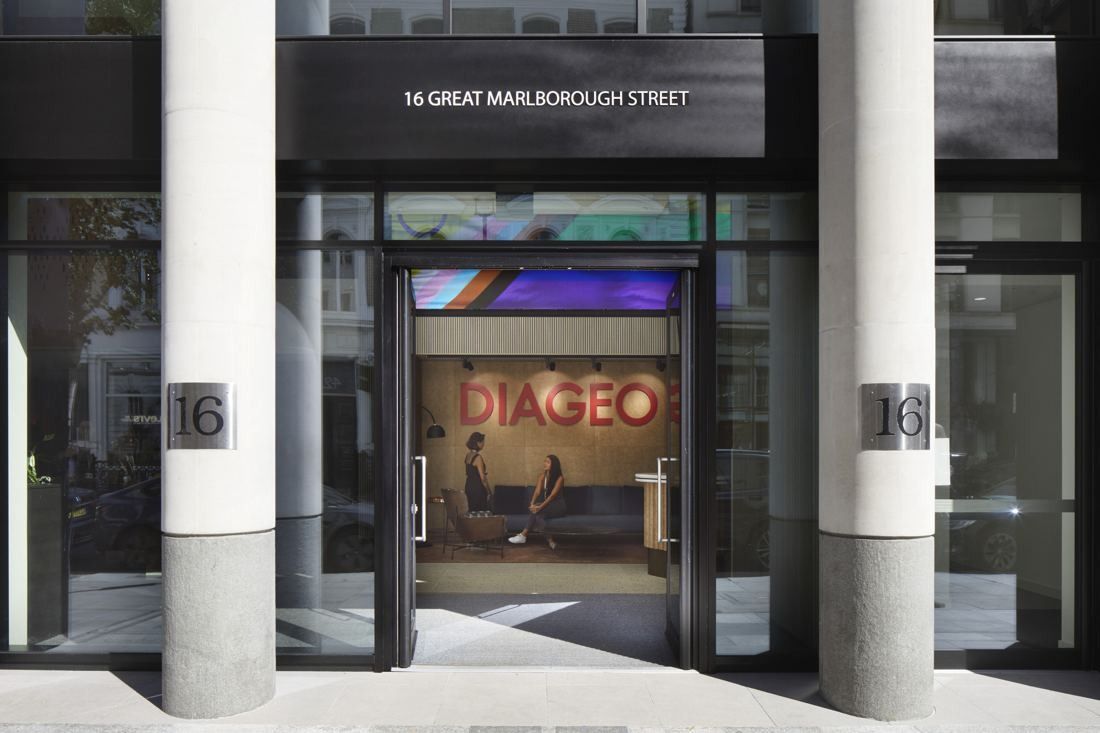 Diageo: Glazed entrance between stone columns marked 16, with a lit reception sign visible inside
